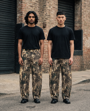 Two models wearing the Heavyweight Tree Camo Barrel Leg Pant in Brown Tree Camo, New Orleans Warehouse District